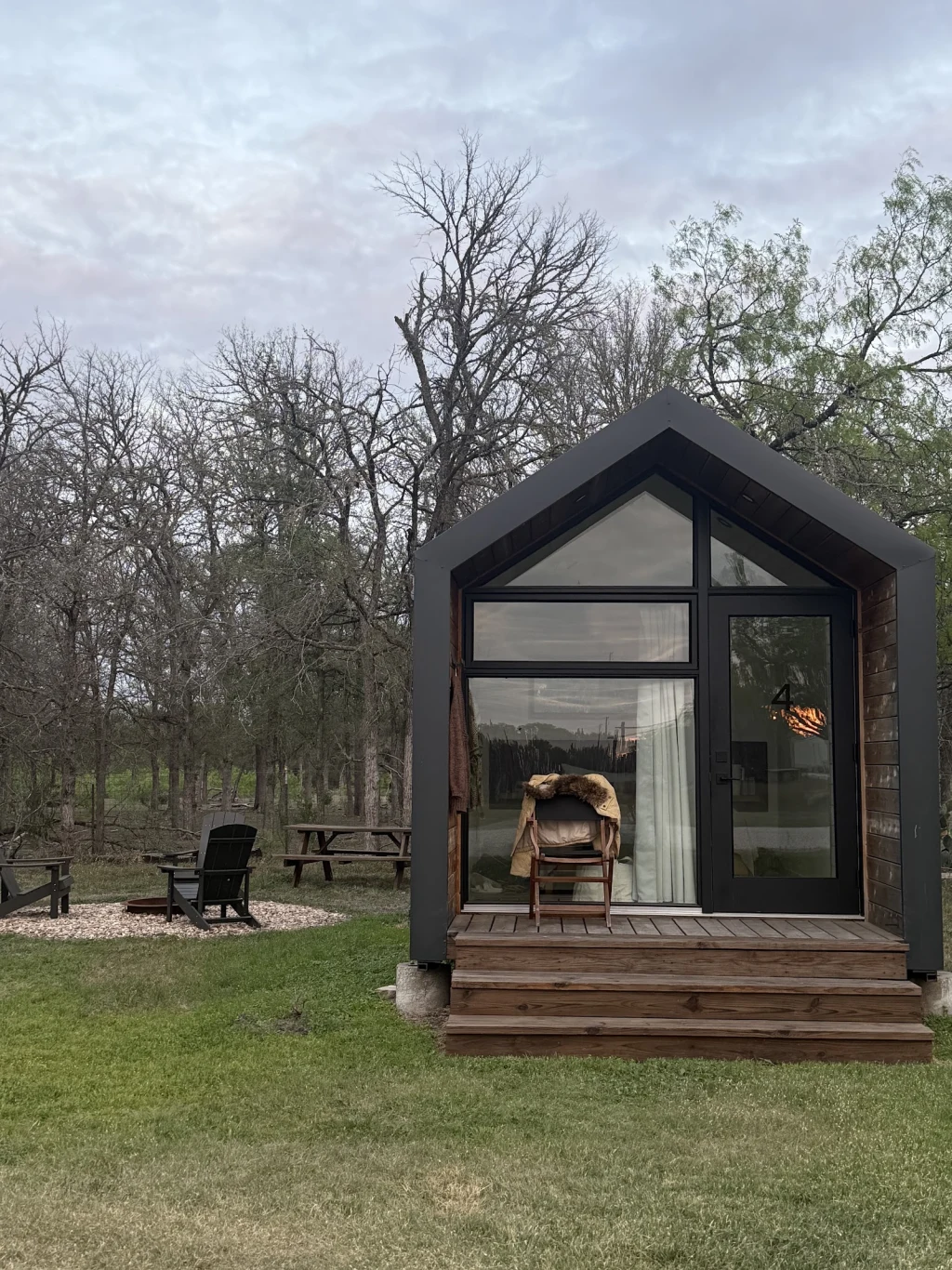Cabin exterior at dusk with Adirondack chairs at Rancho Moonrise