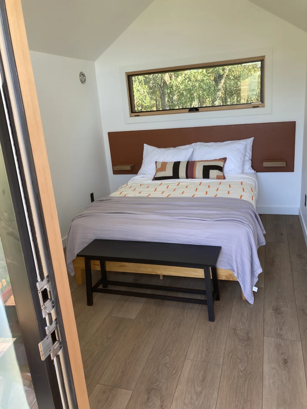 Cabin bedroom with bed and bench at Rancho Moonrise