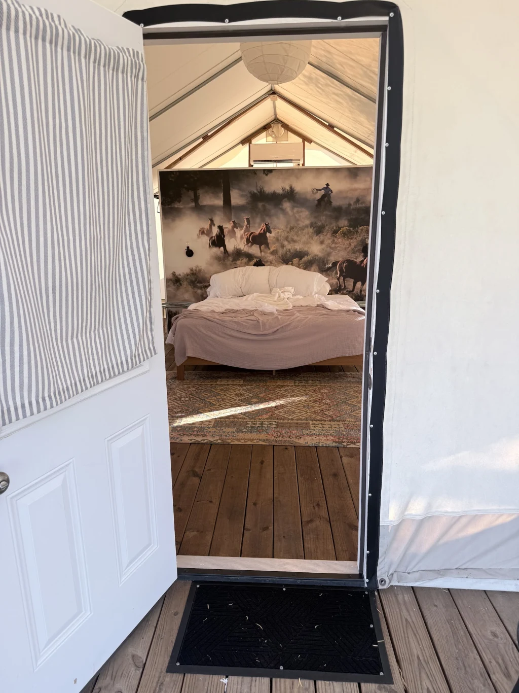 Safari tent doorway showing Western mural above the bed