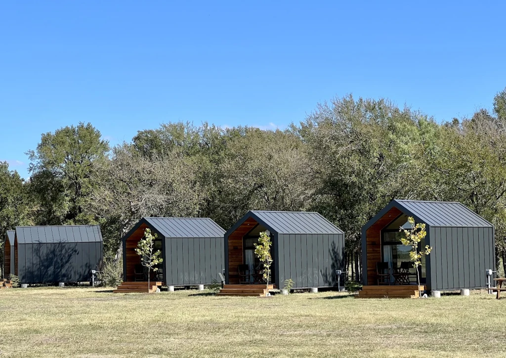 Row of hand-crafted cabins in a field at Rancho Moonrise