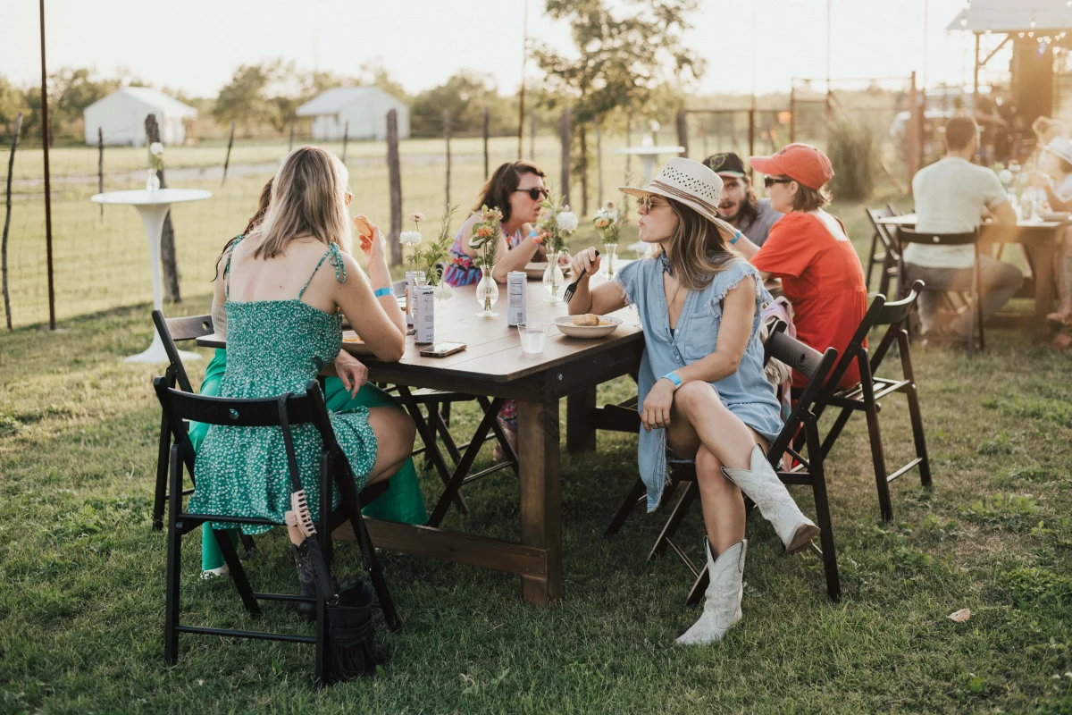 Team of coworkers at an outdoor fire pit during a corporate retreat at a ranch near Austin Texas