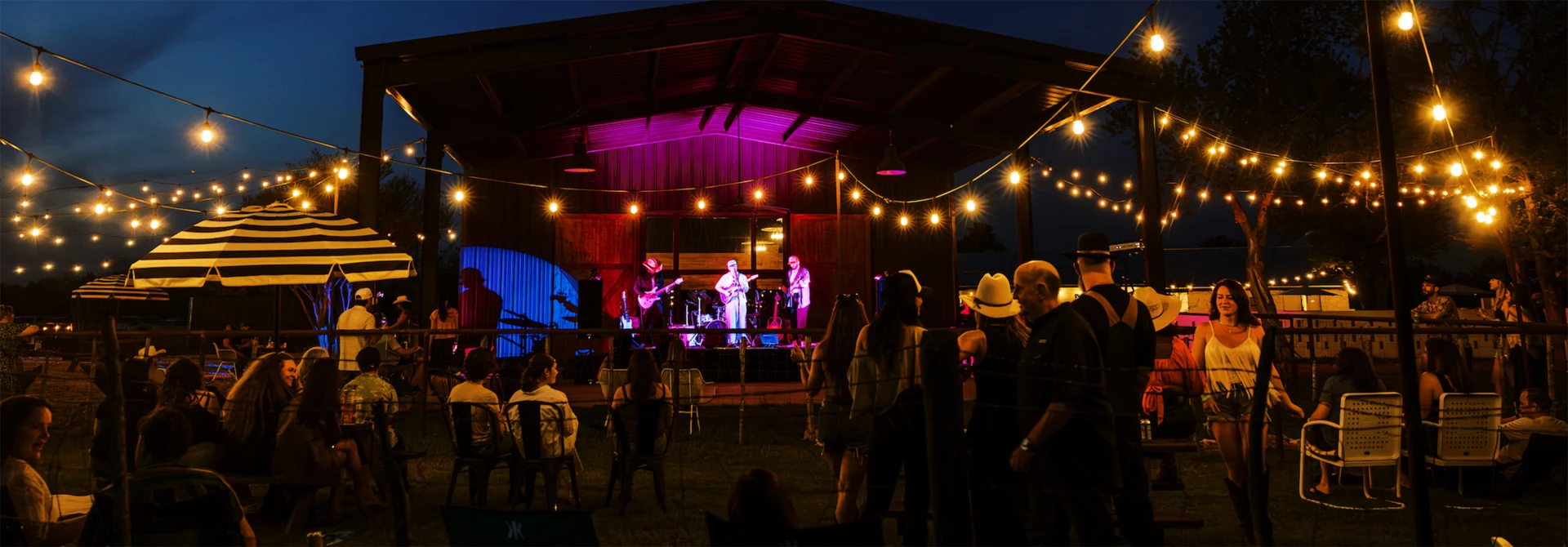 Live music performance at night under string lights at Rancho Moonrise with audience