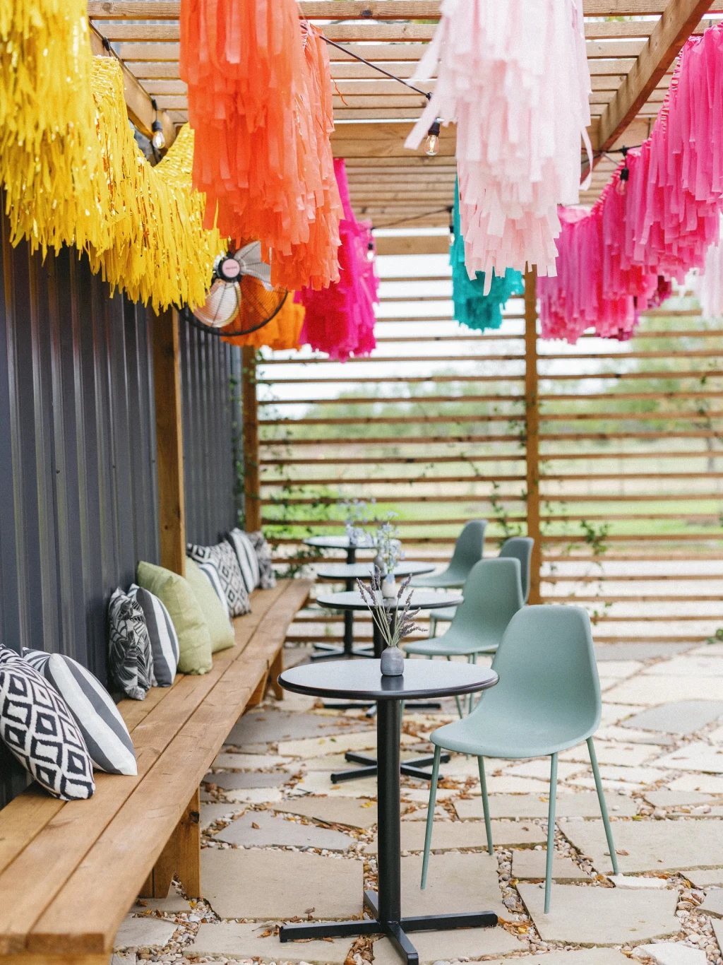 Colorful fringe pergola with patterned pillows and chairs at Rancho Moonrise