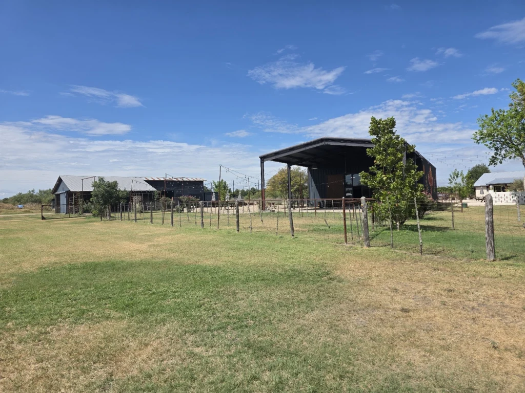 Wide view of Rancho Moonrise grounds showing barns, pasture, and cabins
