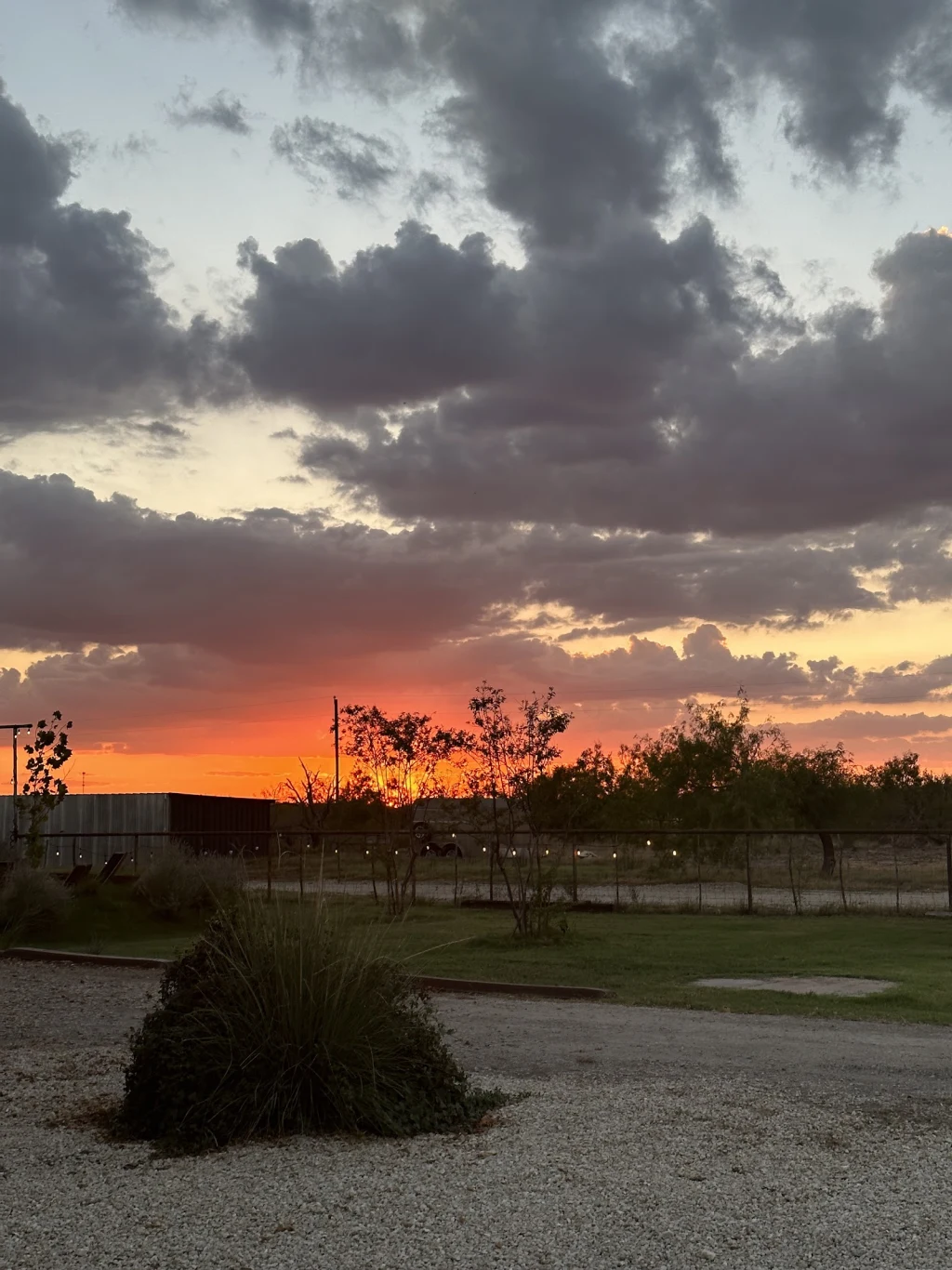 Sunset over the ranch with grass and gravel path in foreground