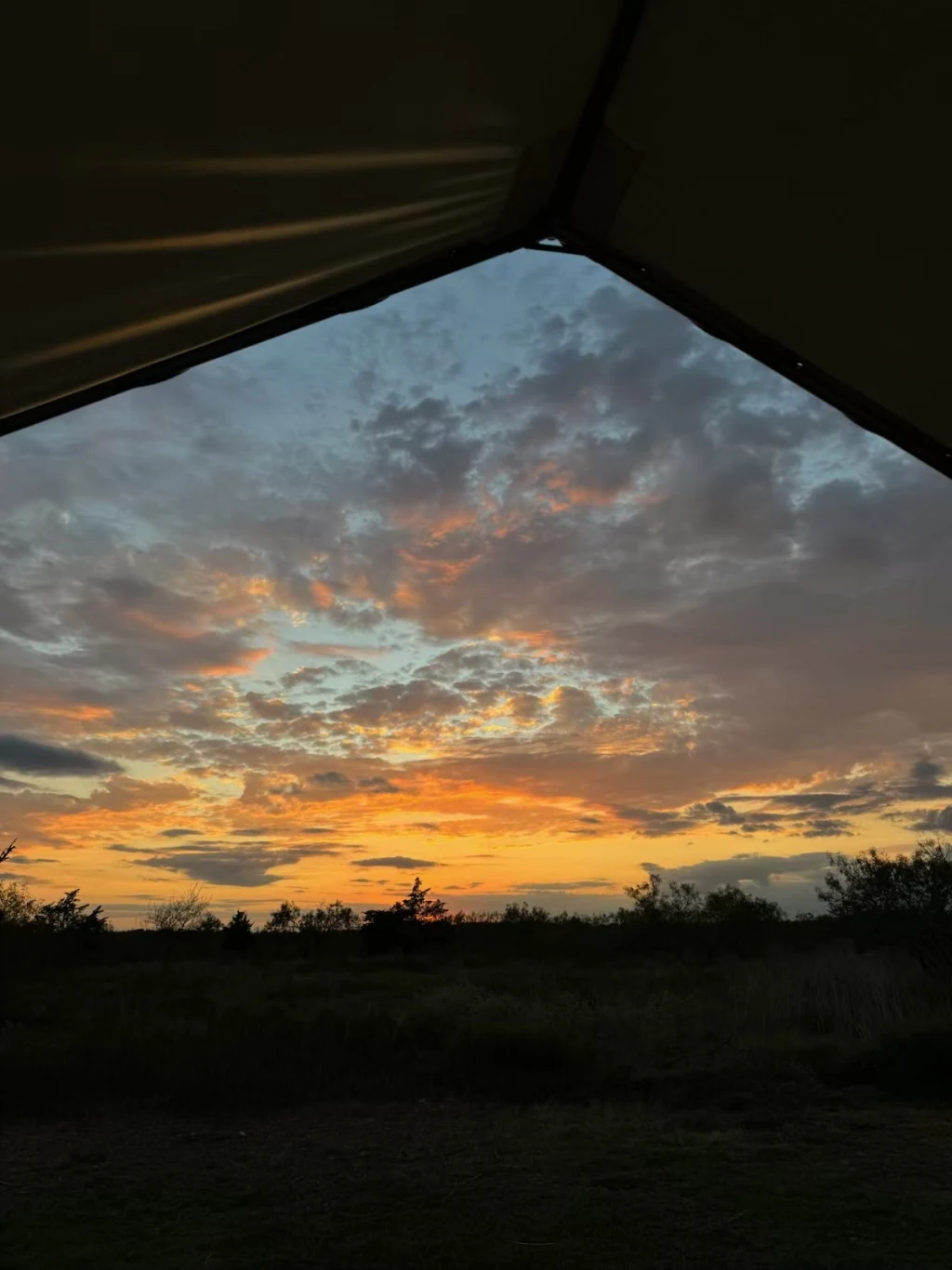 Sunset view through the open flap of a safari tent at Rancho Moonrise
