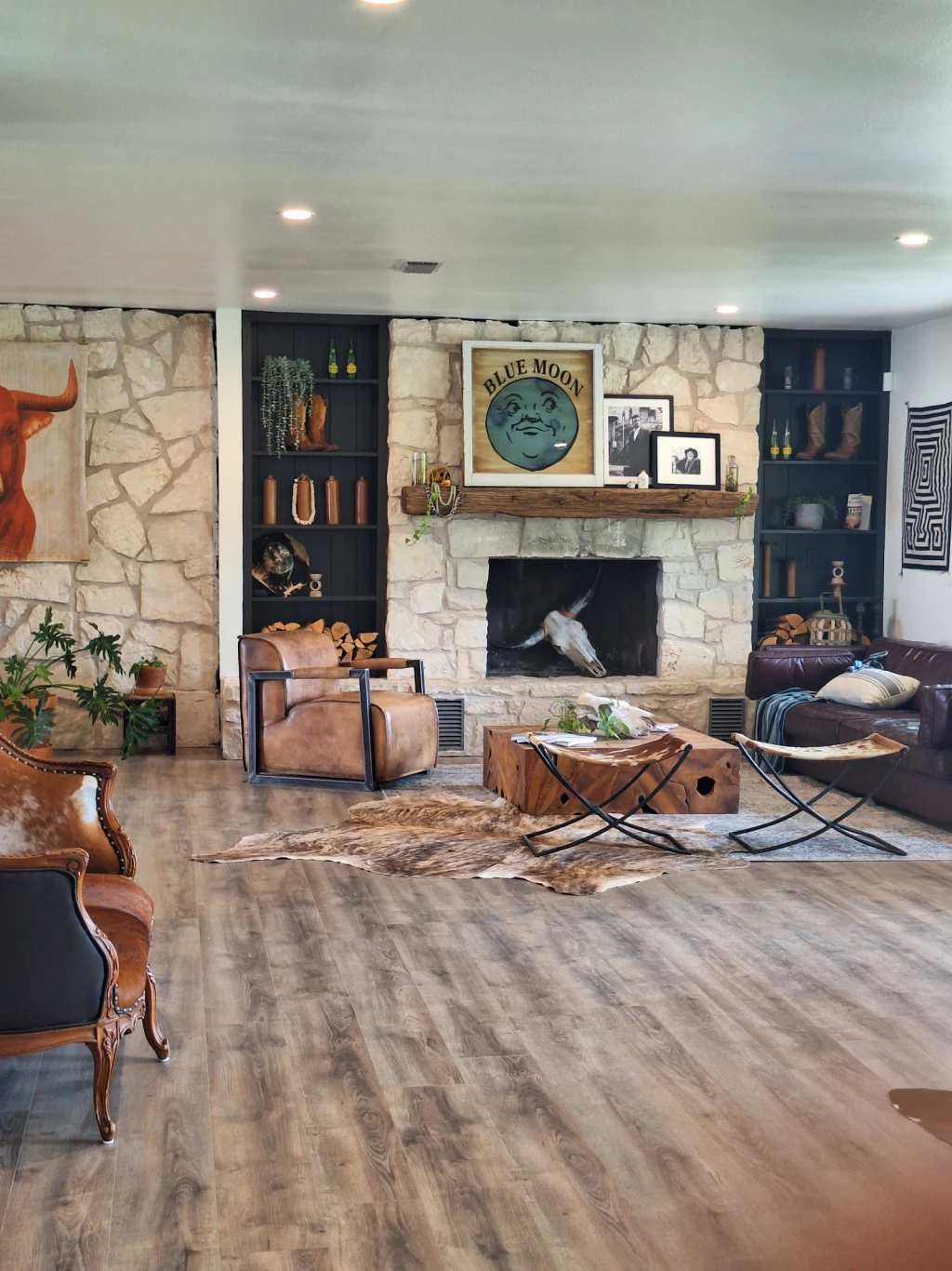 Lodge living room with stone fireplace and cowhide rugs