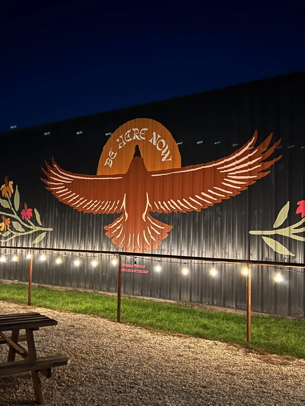 Be Here Now thunderbird mural lit at night at Rancho Moonrise