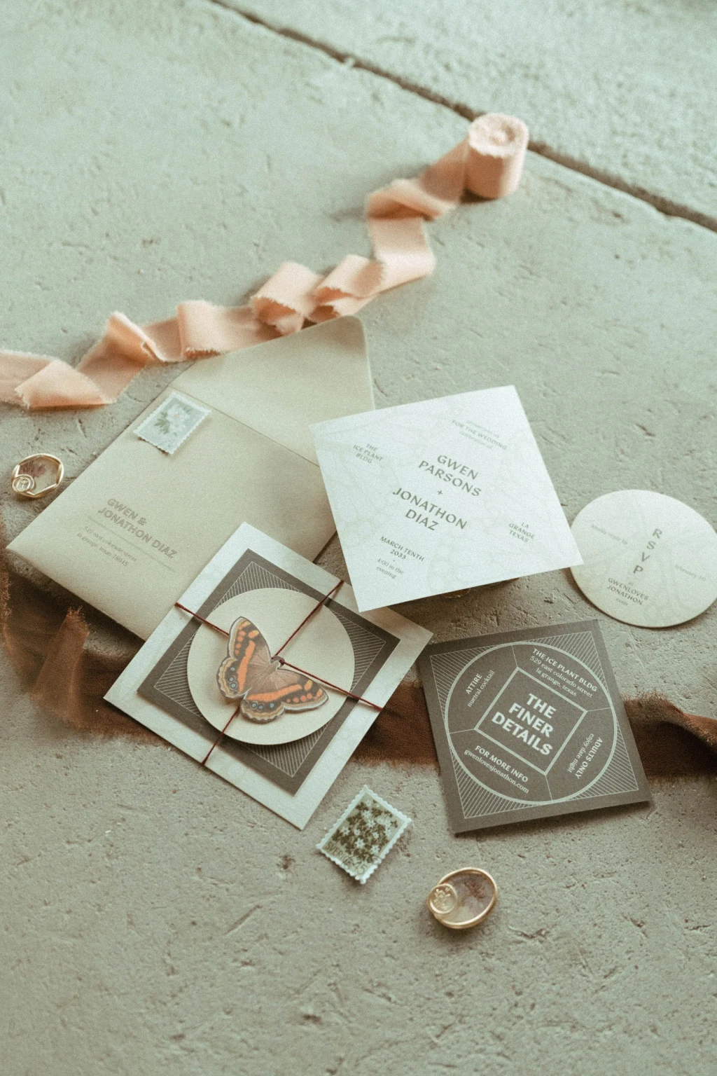 Wedding invitation suite flat-lay with butterfly details and silk ribbon