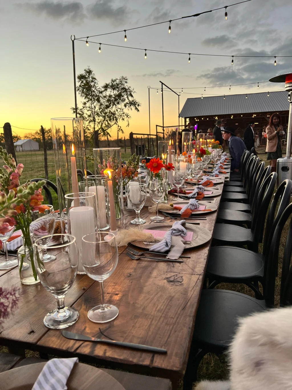 Long reception table at sunset with florals and candles at Rancho Moonrise
