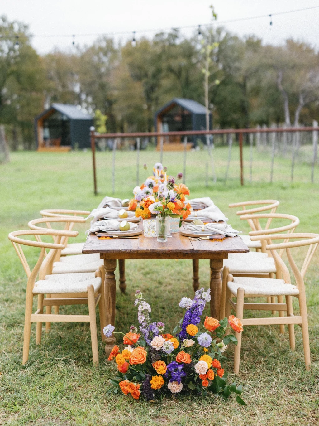 Wedding reception table with wishbone chairs and floral arrangement at Rancho Moonrise